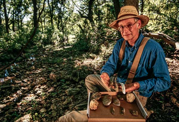 Photo of Mike Collins examining stone artifacts