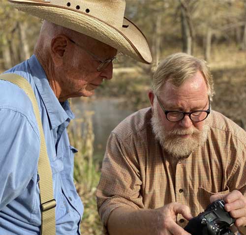 Photos of Kenneth Garret reviewing photos with Mike Collins