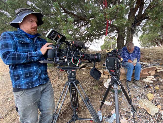 Photo of a production team camera operator shooting at expert demonstrating flint knapping